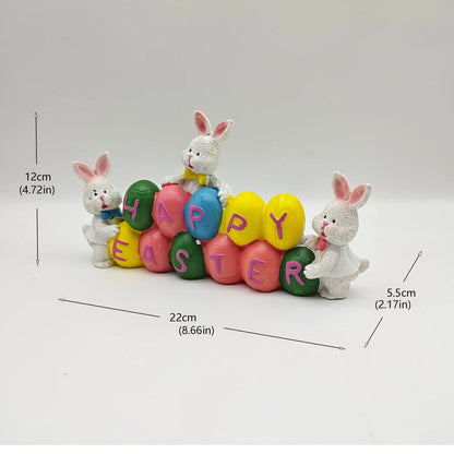 Coelhinho da Páscoa segurando ovos e decorações de Páscoa feliz, estatueta de coelho